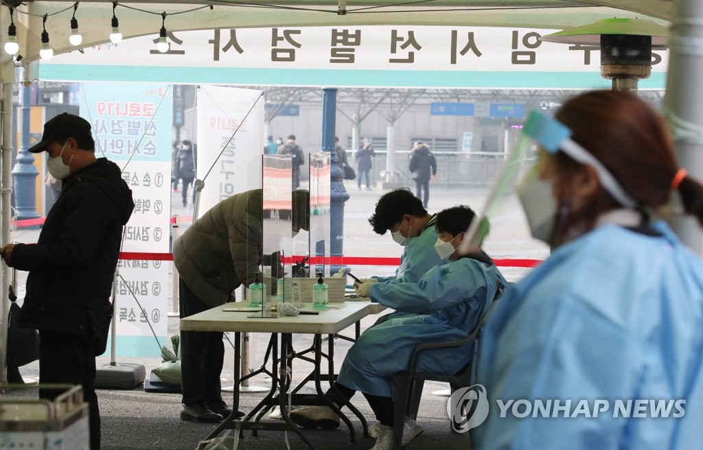 Citizens wait to receive coronavirus tests at a makeshift testing site in front of Seoul Station in central Seoul on Feb. 20, 2021. (Yonhap)