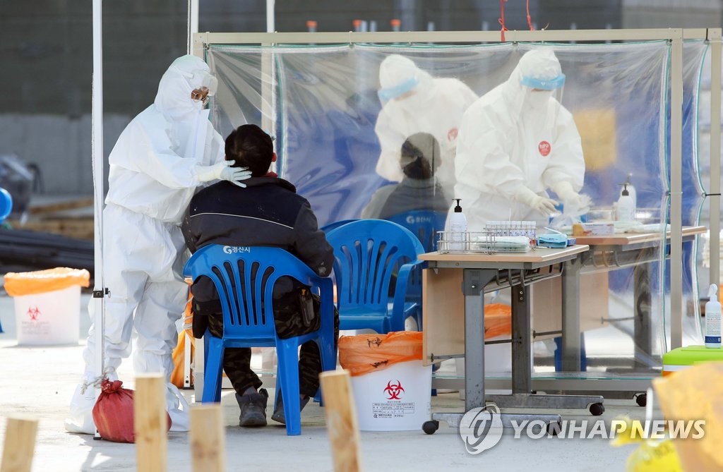 Migrant workers receive tests at an outdoor COVID-19 testing station in Gyeongsan, North Gyeongsang Province, on March 11, 2021, as local authorities ordered all such workers to undergo tests. (Yonhap)