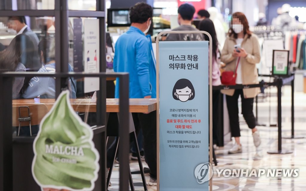 ソウル市内の百貨店に立てられた「マスク着用義務化措置」の案内＝１１日、ソウル（聯合ニュース）