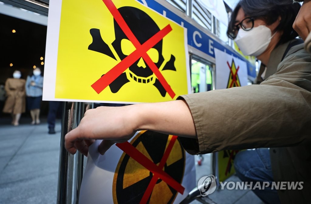 Student activists protesting against Japan's decision to discharge radiation-tinted water from the crippled Fukushima nuclear power plant place protest flyers on a police line set up in front of the Japanese embassy in Seoul on April 14, 2021. (Yonhap) 