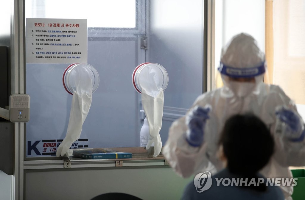 A medical worker conducts a COVID-19 test at a testing center in the southwestern city of Gwangju, 329 kilometers south of Seoul, on April 27, 2021, in this photo provided by Gwangju's Buk District office. (PHOTO NOT FOR SALE) (Yonhap) 
