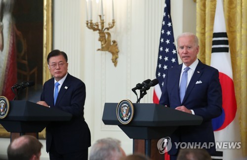 首脳会談後の共同記者会見に臨む文大統領（左）とバイデン大統領＝２１日、ワシントン（聯合ニュース）