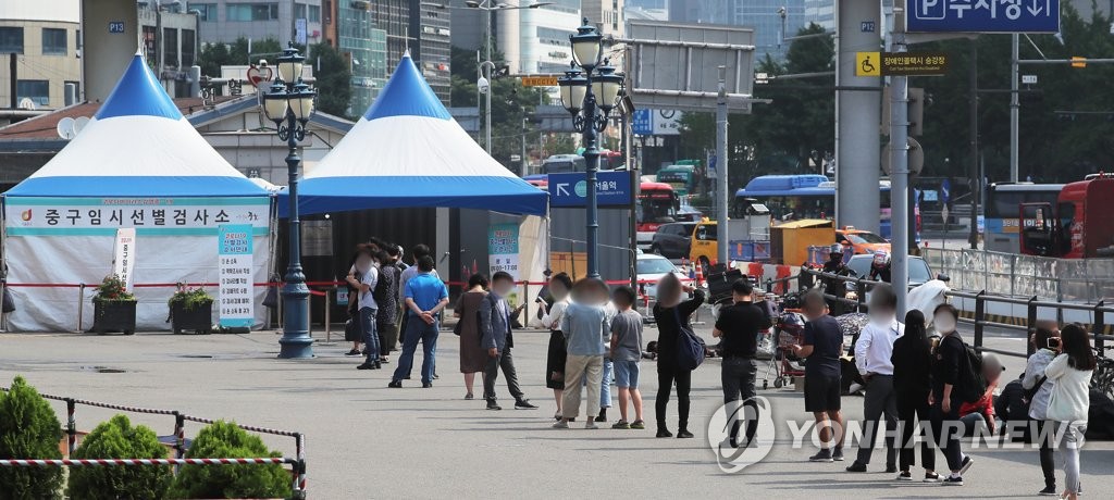 Des citoyens font la queue pour se faire dépister pour le nouveau coronavirus (Covid-19) devant le centre sur la place de la gare de Séoul le mardi 8 juin 2021. 