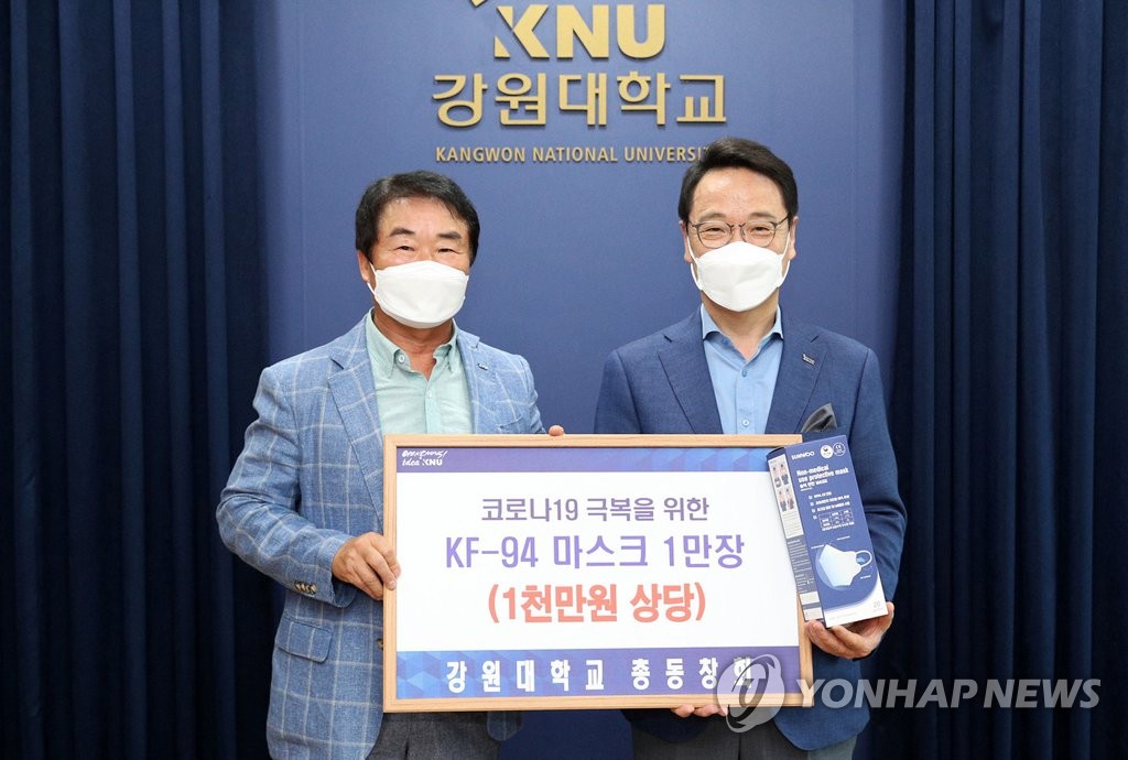 지난해 6월 이필현 강원대 총동문회장(왼쪽), 김헌영 총장(오른쪽)에 마스크 1만 장 전달
