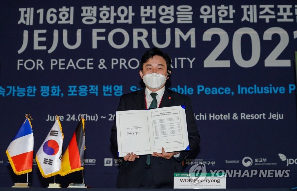 Le gouverneur de Jeju, Won Hee-ryong, pose le 25 juin 2021 après avoir signé un communiqué conjoint avec les villes de Verdun et d'Osnabrück pour une solidarité pour la paix au cours du 16e Forum de Jeju. 