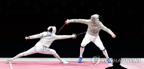 Kim Jung-hwan of South Korea (L) attacks Sandro Bazadze of Georgia during the bronze medal match of the men's individual sabre event at the Tokyo Olympics at Makuhari Messe Hall B in Chiba, Japan, on July 24, 2021. (Yonhap)