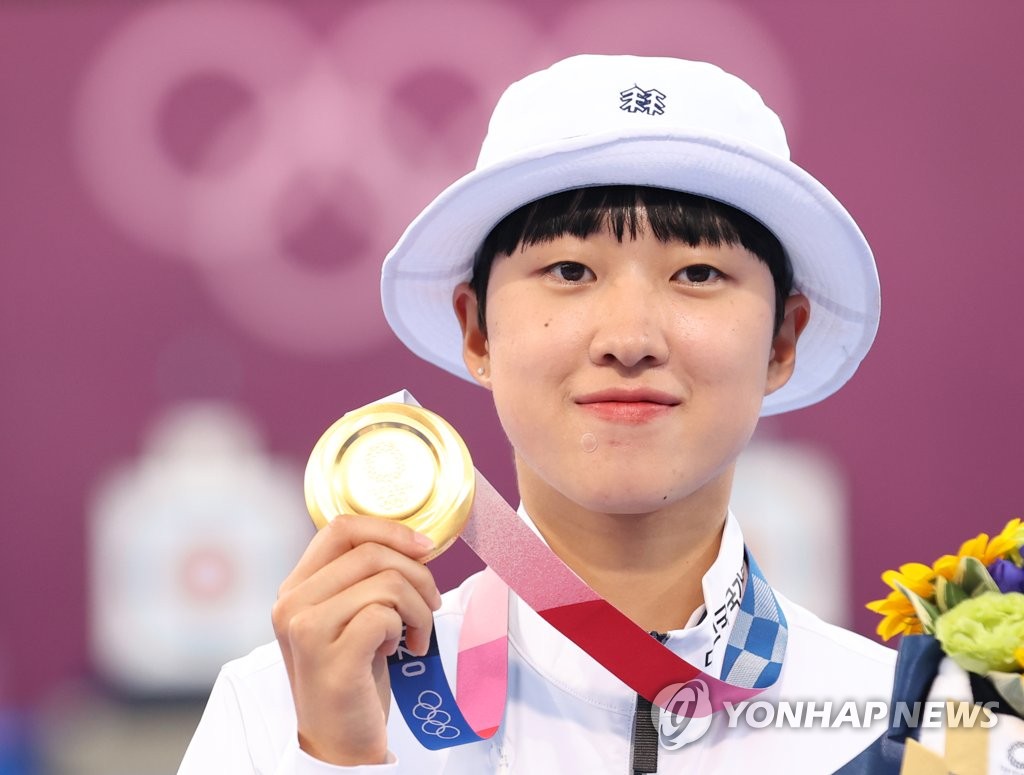 In this file photo, An San of South Korea holds up her gold medal from the women's individual archery event at the Tokyo Olympics at Yumenoshima Park Archery Field in Tokyo on July 30, 2021. (Yonhap)