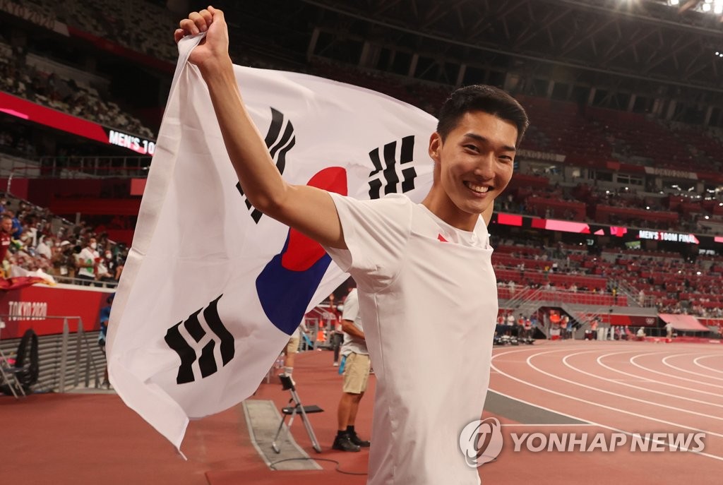 Le sauteur en hauteur Woo Sang-hyeok manifeste sa joie après avoir terminé quatrième avec un nouveau record national de 2,35 mètres au stade national à Tokyo le dimanche 1er août 2021. 
