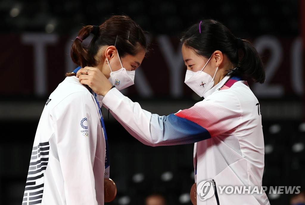 South Korean badminton player Kong Hee-yong (R) puts the bronze medal around the neck of her doubles partner Kim So-yeong after winning bronze in the women's doubles at the Tokyo Olympics at Musashino Forest Plaza in Tokyo on Aug. 2, 2021. (Yonhap)