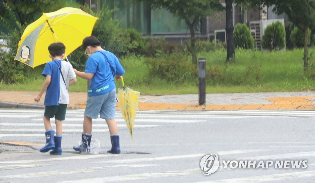 비 오는 거리를 걷는 아이들