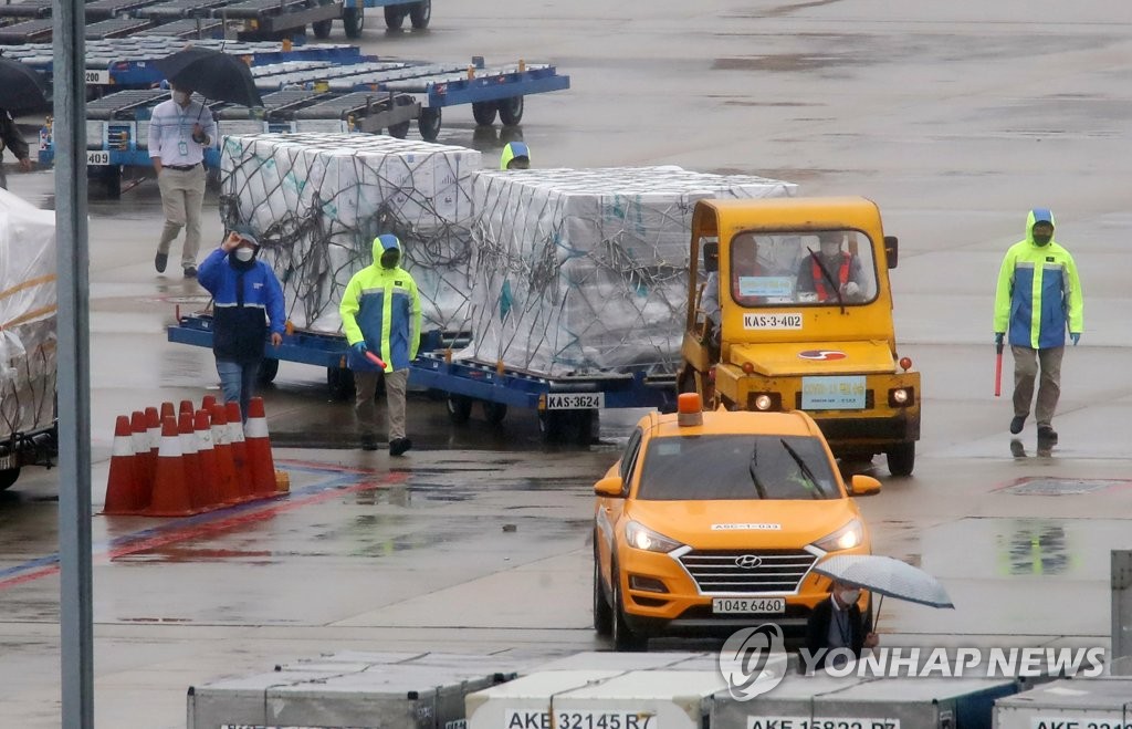 Workers move boxes carrying 442,000 doses of Pfizer Inc.'s COVID-19 vaccine, which the government secured under a direct contract with the pharmaceutical giant, from a chartered plane at Incheon International Airport, west of Seoul, on Oct. 6, 2021. (Yonhap)