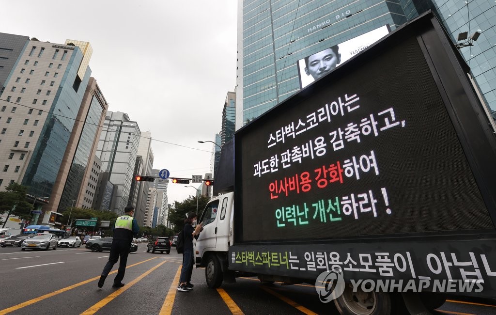 A truck hired by Starbucks Coffee Korea employees stands on a road in southern Seoul on Oct. 7, 2021, carrying a sign calling for the improvement of their working conditions. (Yonhap)