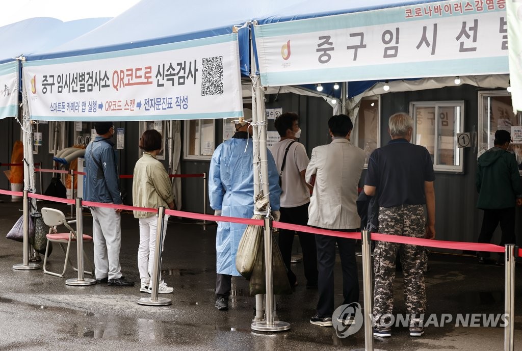 People wait in line to receive virus tests at a makeshift COVID-19 testing clinic in Seoul on Oct. 11, 2021. (Yonhap)