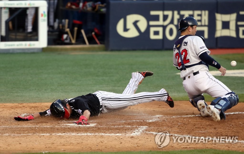 Ahn Ik-hun of the LG Twins (L) slides home safely against the Doosan Bears during the top of the ninth inning of a Korea Baseball Organization regular season game at Jamsil Baseball Stadium in Seoul on Oct. 24, 2021. (Yonhap)