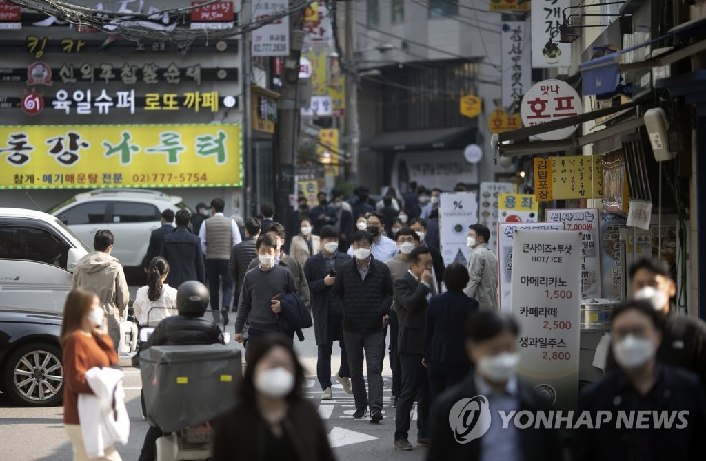 People walk on a side street full of restaurants in Seoul during lunchtime on Oct. 26, 2021. (Yonhap)