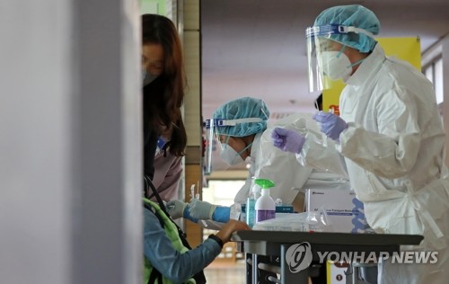 Medical workers conduct COVID-19 tests on students at an elementary school in the central city of Daejeon on Oct. 26, 2021. (Yonhap)