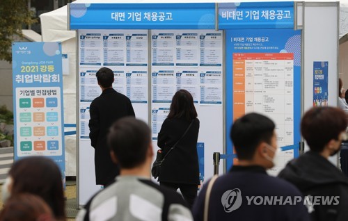 De jeunes chercheurs d'emploi regardent des annonces à un salon de l'emploi à Séoul, le jeudi 4 novembre 2021. 