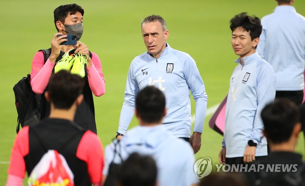 Paulo Bento (C), head coach of the South Korean men's national football team, speaks with his staff and players before a training session at Al-Sailiya Sports Club in Doha on Nov. 14, 2021, in preparation for a World Cup qualifying match against Iraq. (Yonhap)