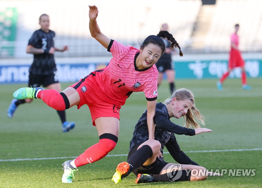 Choe Yu-ri of South Korea (L) is tackled by Betsy Hassett of New Zealand during their teams' friendly football match at Goyang Stadium in Goyang, Gyeonggi Province, on Nov. 27, 2021. (Yonhap)