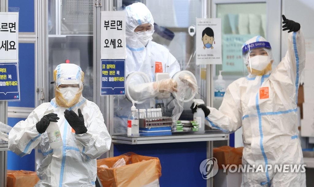 Medical workers carry out their job at a COVID-19 testing booth at a public health center in Seoul's southeastern district of Songpa on Nov. 28, 2021. (Yonhap)
