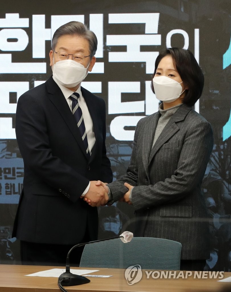 Lee Jae-myung (L), the presidential candidate of the ruling Democratic Party, poses for a photo with Cho Dong-youn, a military science professor, during a ceremony at the party's headquarters in Seoul on Nov. 30, 2021, to mark the designation of Cho as a co-leader of Lee's election campaign committee. (Pool photo) (Yonhap)