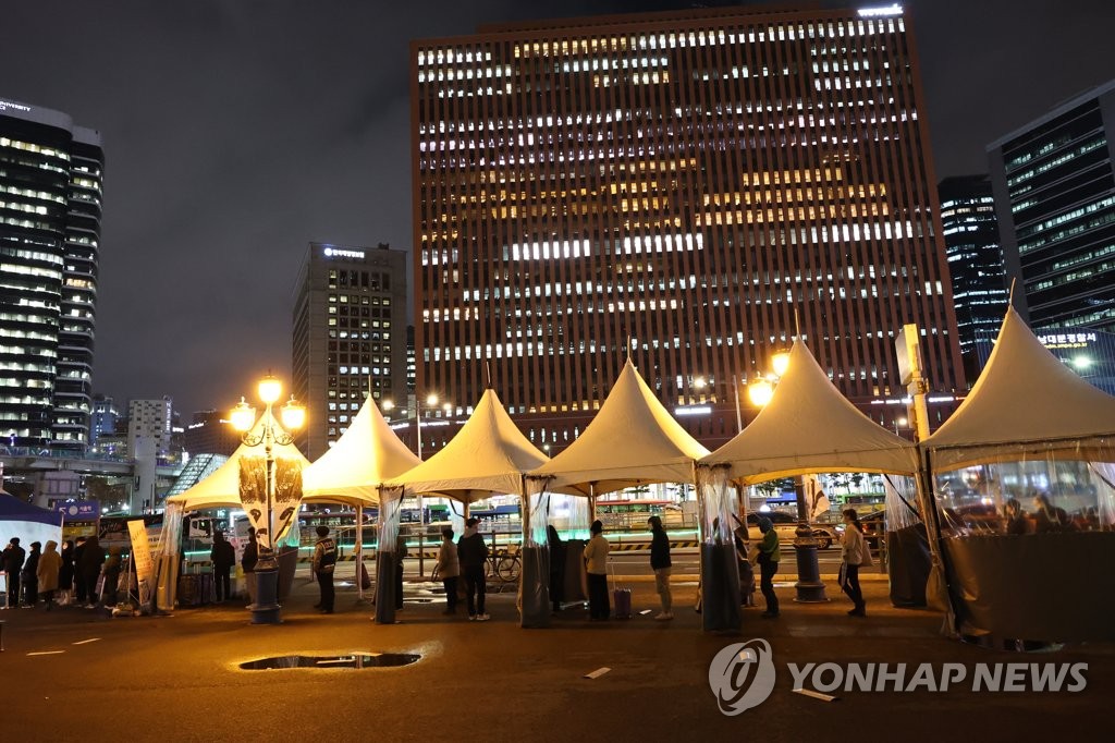 Des personnes font la queue pour subir un test de dépistage du nouveau coronavirus (Covid-19) le soir du mardi 30 novembre 2021, devant un centre installé sur la place de la gare de Séoul. 