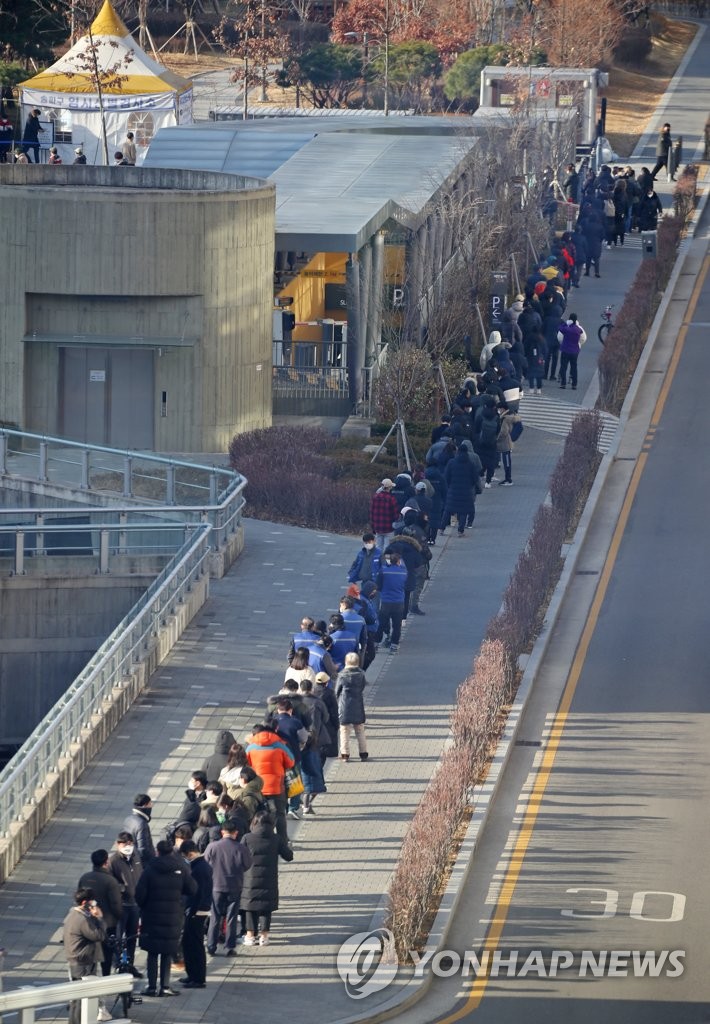 People wait in line for coronavirus tests at a pop-up screening clinic in Seoul's Songpa Ward on Dec. 22, 2021. South Korea's new coronavirus cases spiked to above 7,000 the same day and the number of critically ill patients surged to a record high of 1,063. (Yonhap)