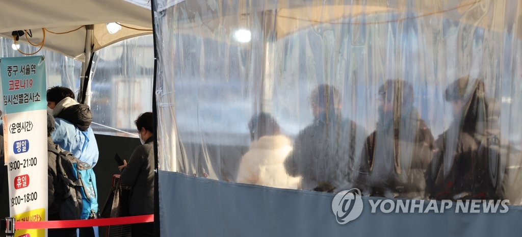 Citizens stand in line to take coronavirus tests at a screening clinic in front of Seoul Station on Jan. 5, 2022. (Yonhap) 
