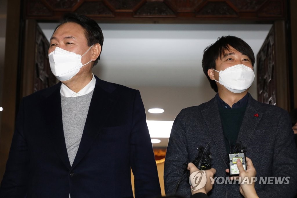 This photo taken Jan. 6, 2022, shows Yoon Suk-yeol (L), the presidential candidate of the People Power Party (PPP), and PPP Chairman Lee Jun-seok speaking to reporters after the party's general meeting at the National Assembly in Seoul. (Pool photo) (Yonhap)