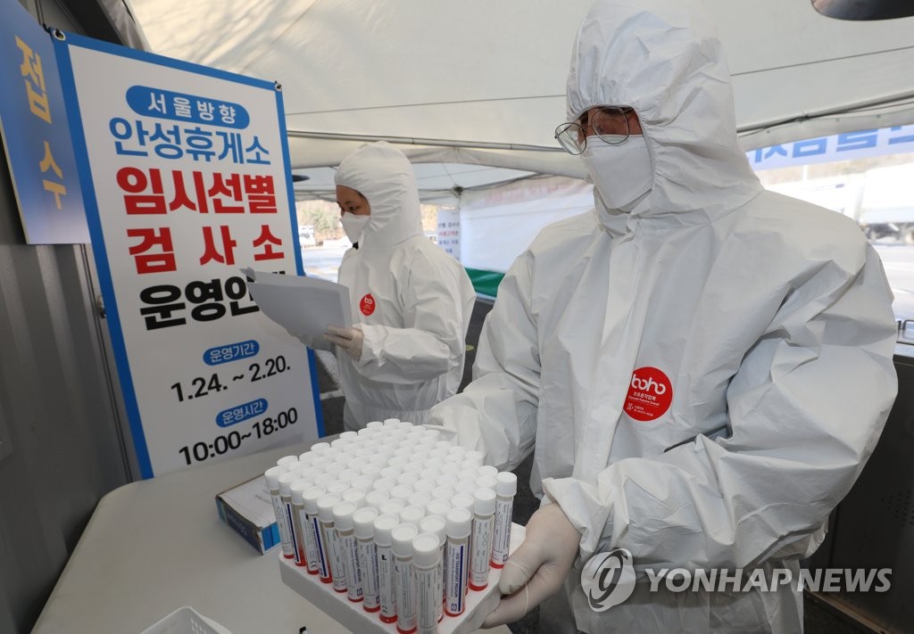 A medical worker checks COVID-19 test kits at a makeshift testing station at the Anseong Rest Area on the Seoul-bound Gyeongbu Expressway in Gyeonggi Province on Jan. 24, 2022. (Yonhap) 