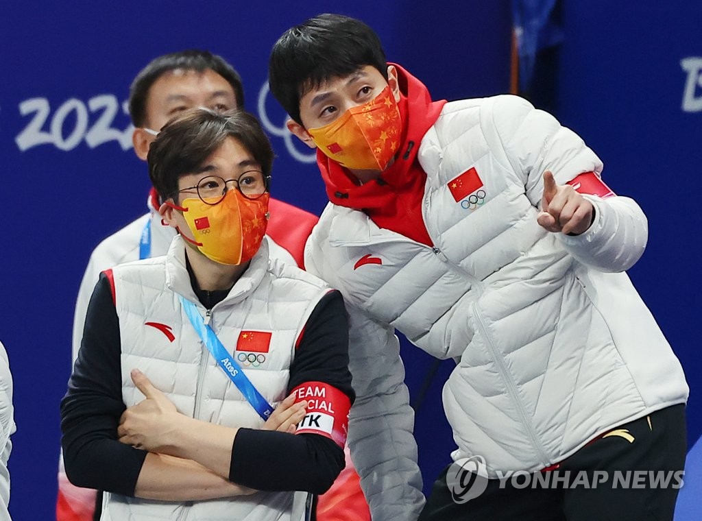 Kim Sun-tae (L) and Victor An, the South Korean-born head coach and technical coach of the Chinese national short track speed skating team, await the result of the official ruling after China's semifinal race in the mixed team relay at the Beijing Winter Olympics at Capital Indoor Stadium in Beijing on Feb. 5, 2022. (Yonhap)