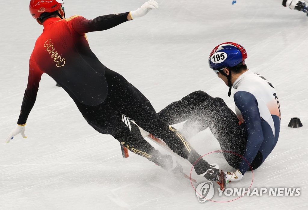 Park Jang-hyuk of South Korea (R) injures his left hand as Wu Dajing of China clips him with his skate during the men's 1,000m short track speed skating quarterfinals at the Beijing Winter Olympics at Capital Indoor Stadium in Beijing on Feb. 7, 2022. (Yonhap)