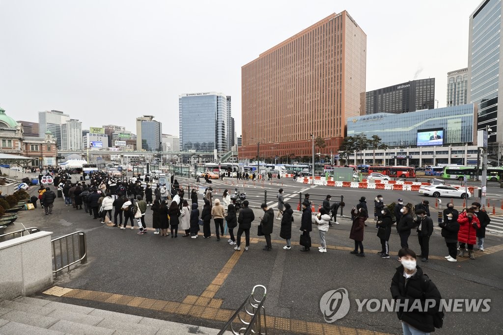 People wait in line to receive tests at a COVID-19 testing station in Seoul on Feb. 14, 2022, when the country reported 54,619 new cases. (Yonhap)