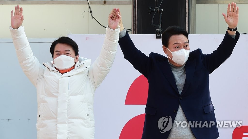 Yoon Suk-yeol (R), the presidential candidate of the main opposition People Power Party, and Ahn Cheol-soo of the People's Party pose for a photo during Yoon's campaign rally in Hanam, Gyeonggi Province, on March 7, 2022. (Yonhap)