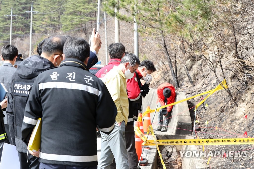 Police and fire officials conduct a joint probe on March 16, 2022, at a east coast mountain site in Uljin, 330 kilometers southeast of Seoul, believed to be the ignition point of a recent wildfire reported as the most devastating of its kind on record in South Korea. (Yonhap)