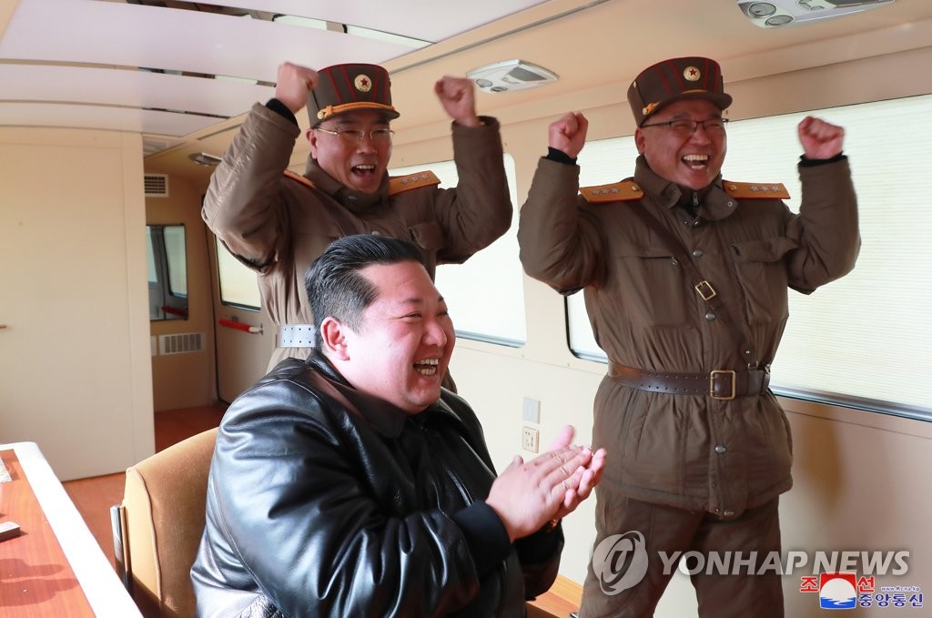 North Korean leader Kim Jong-un (front), accompanied by Jang Chang-ha (L, rear), chief of the North's Academy of National Defense, and Kim Jong-sik, the deputy director of the Munitions Industry Department, celebrates after a Hwasong-17 intercontinental ballistic missile (ICBM) was launched from Pyongyang International Airport on March 24, 2022, in this photo released by North Korea's official Korean Central News Agency. The missile traveled up to a maximum altitude of 6,248.5 kilometers and flew a distance of 1,090 km before falling into the East Sea, the KCNA said. (For Use Only in the Republic of Korea. No Redistribution) (Yonhap)
