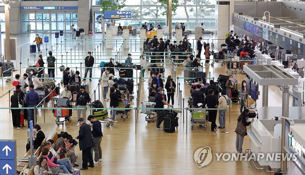 资料图片：4月22日，在仁川机场，准备出境的旅客正在等待办理登机手续。 韩联社