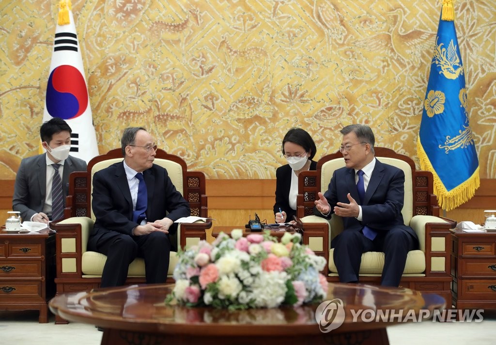 President Moon Jae-in (R) talks with Chinese Vice President Wang Qishan at the presidential office in Seoul on May 9, 2022. Wang visited Seoul earlier in the day to attend the inaugural ceremony of President-elect Yoon Suk-yeol the following day. (Yonhap)