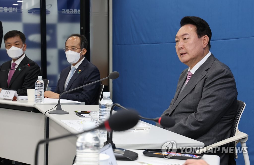 President Yoon Suk-yeol (R) speaks at a meeting discussing the macro-financial situation at the Korea Center for International Finance in Seoul on May 13, 2022. (Yonhap)