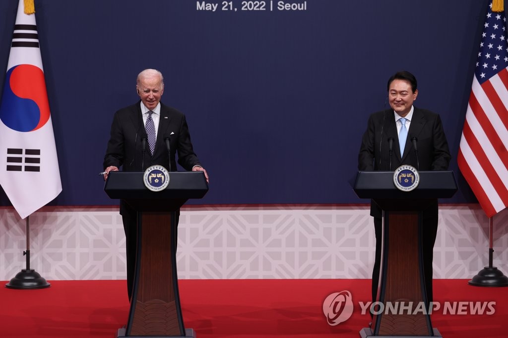 El presidente surcoreano, Yoon Suk-yeol (dcha.), y su homólogo estadounidense, Joe Biden, escuchan preguntas de los reporteros sonriendo durante una conferencia de prensa conjunta, el 21 de mayo de 2022, después de sostener una reunión cumbre bilateral, en la oficina presidencial, en Yongsan, en Seúl.