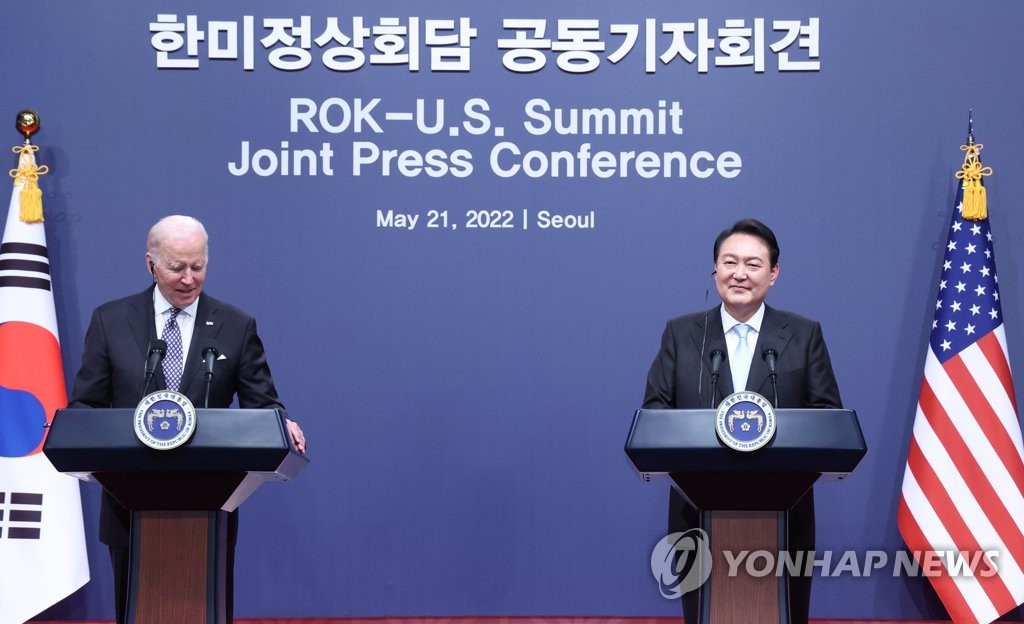 El presidente surcoreano, Yoon Suk-yeol (dcha.), y su homólogo estadounidense, Joe Biden, escuchan preguntas de los reporteros sonriendo durante una conferencia de prensa conjunta, el 21 de mayo de 2022, después de sostener una reunión cumbre bilateral, en la oficina presidencial, en Yongsan, en Seúl.