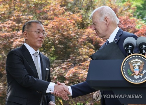 バイデン大統領と握手を交わす鄭氏＝２２日、ソウル（聯合ニュース）