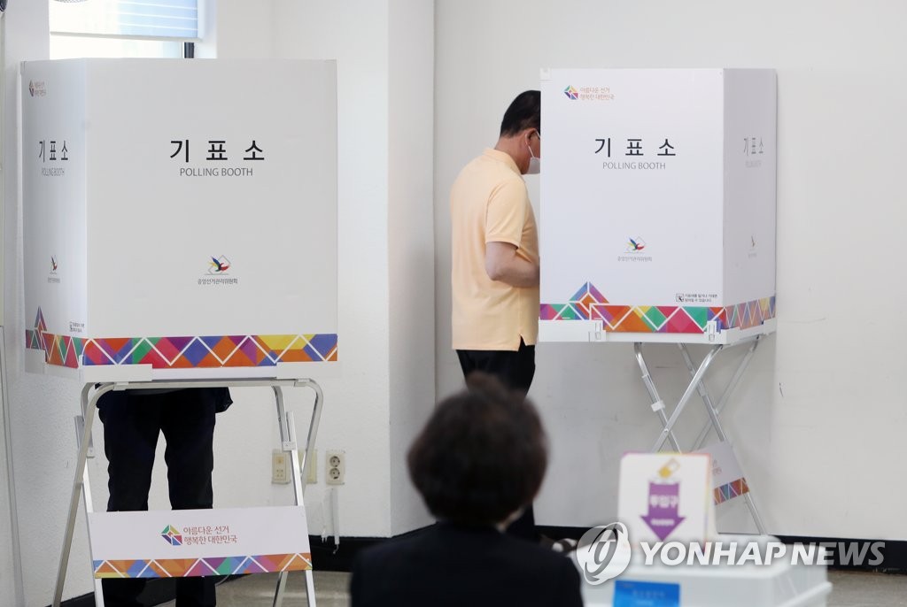 Voters cast ballots at a polling station in Daegu on May 27, 2022, the first day of two-day early voting for the June 1 local elections and parliamentary by-elections. (Yonhap)
