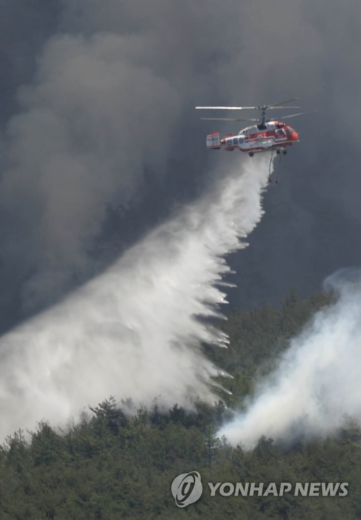 A Korea Forest Service helicopter dumps water on a wildfire in Miryang, South Gyeongsang Province, southeastern South Korea, on May 31, 2022, after it broke out at around 9:25 a.m. (Yonhap)