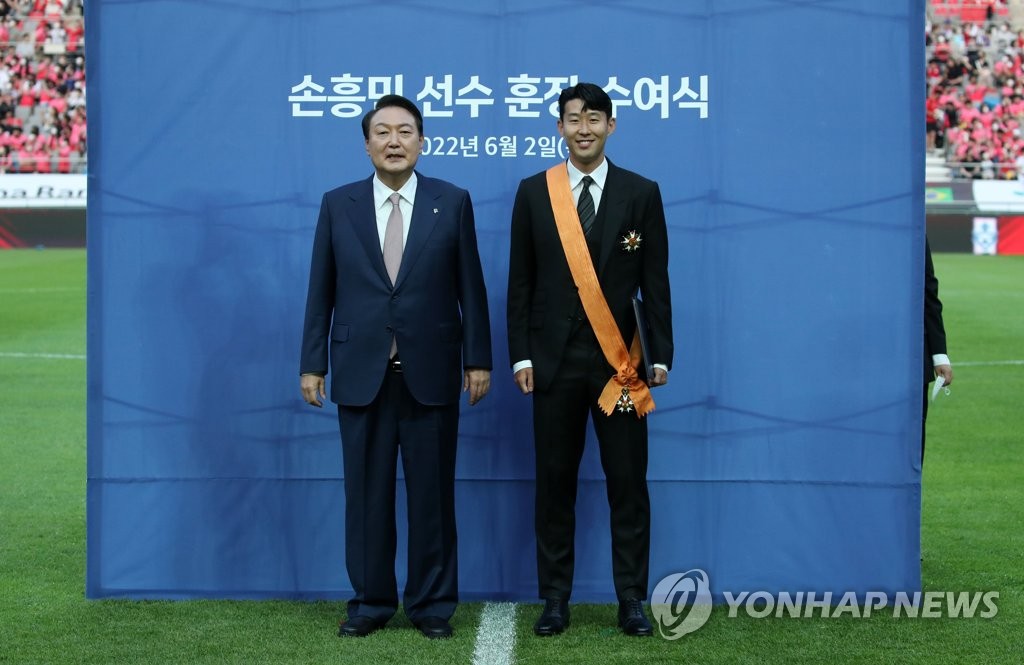 President Yoon Suk-yeol (L) and Son Heung-min, captain of the South Korean men's national football team, pose for photos after Yoon awarded Son with the Cheongnyong Medal, the highest order of merit given to an individual for achievement in sports, prior to South Korea's friendly match against Brazil at Seoul World Cup Stadium in Seoul on June 2, 2022. (Yonhap)