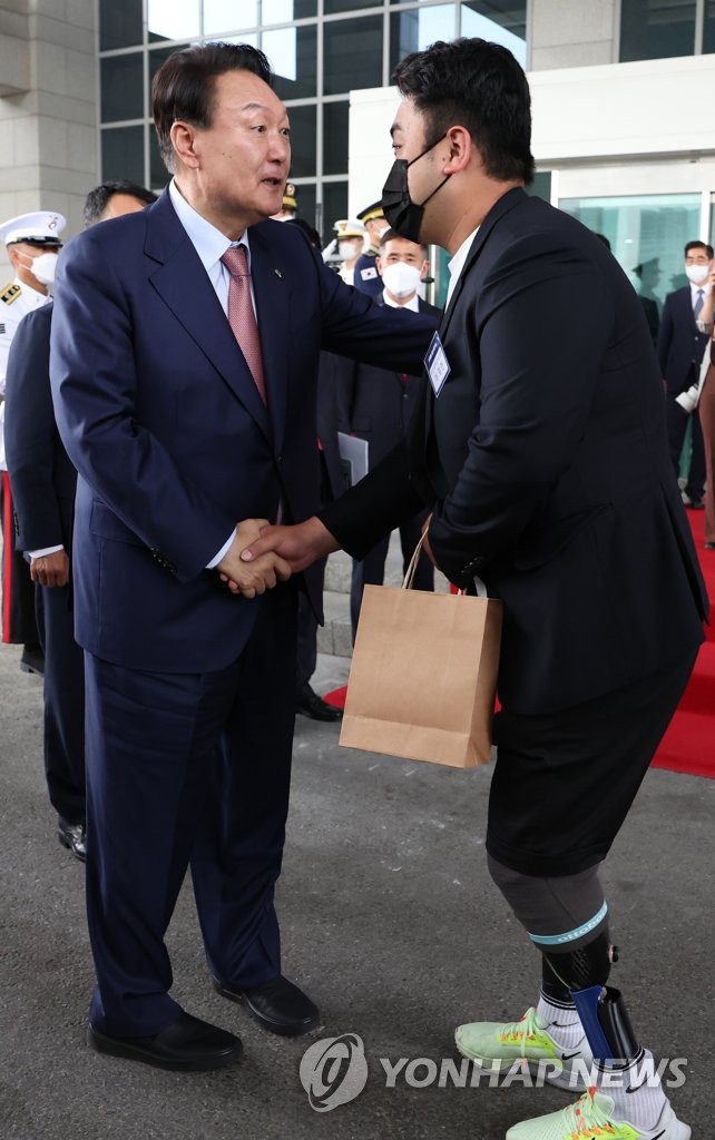 President Yoon Suk-yeol sees off Ha Jae-heon, a reserve Army sergeant first class who was maimed in a border land mine explosion blamed on North Korea in August 2015, after lunch at the presidential office in Seoul on June 9, 2022, in this photo provided by the presidential office. (PHOTO NOT FOR SALE) (Yonhap)