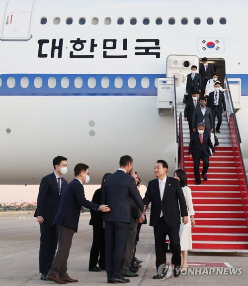 South Korean President Yoon Suk-yeol (2nd from R, on tarmac) and his wife (in white), Kim Keon-hee, arrive at MadridBarajas Airport in Madrid on June 27, 2022, to attend a NATO summit on his first overseas trip as president. (Yonhap)