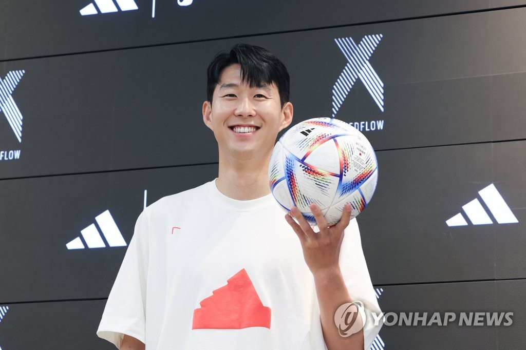 La star de football sud-coréenne Son Heung-min pose avec le ballon officiel de la Coupe du monde 2022 durant un événement au Adidas Brand Center à Mapo dans l'ouest de Séoul, le lundi 4 juillet 2022. 