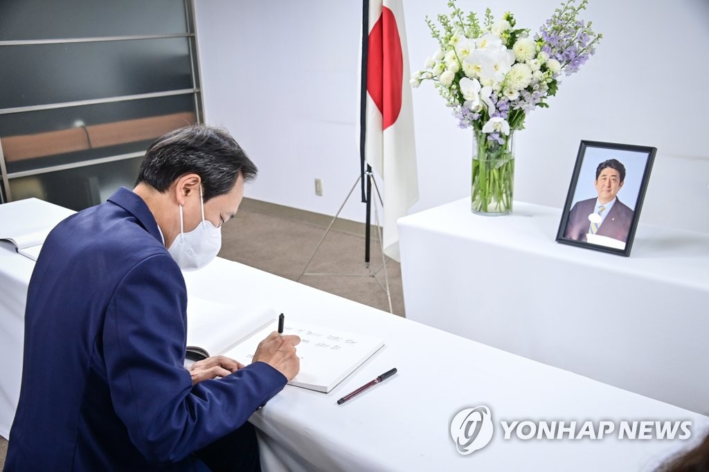 The main opposition Democratic Party leader Woo Sang-ho writes a tribute in a guest book at the memorial altar of former Japanese Prime Minister Shinzo Abe, who was fatally shot during an election campaign speech, set up at the Japanese embassy in downtown Seoul, in this photo provided by the party on July 12, 2022. (PHOTO NOT FOR SALE) (Yonhap)