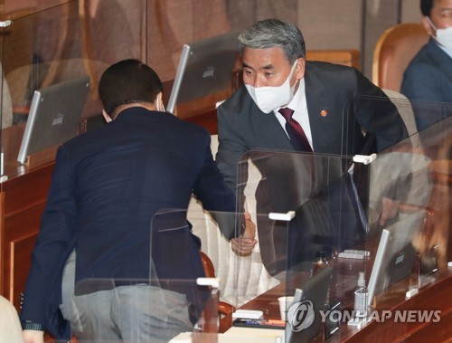 国会で統一部長官（左）と握手する李鐘燮（イ・ジョンソプ）国防部長官（国会写真記者団）＝２５日、ソウル（聯合ニュース）
